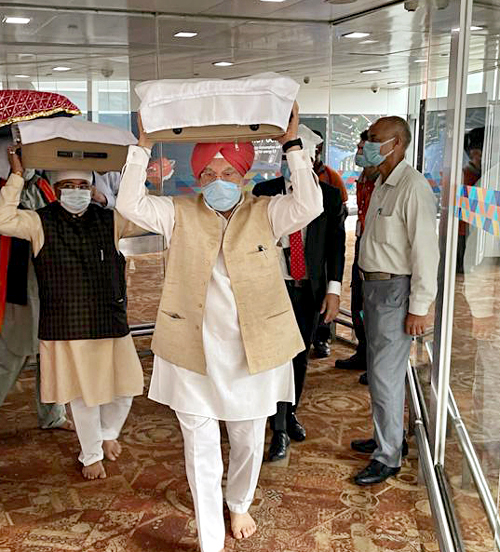 Union Minister Hardeep Singh Puri brings three swaroops of Sri Guru Granth Sahib out of the Delhi airport