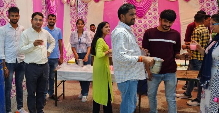 हकेवि में शीतल जल सेवा शिविर में जल वितरण करते विद्यार्थी।