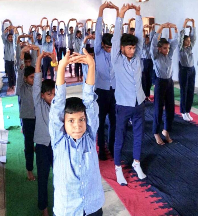 कैंप में योग करते विद्यार्थी।