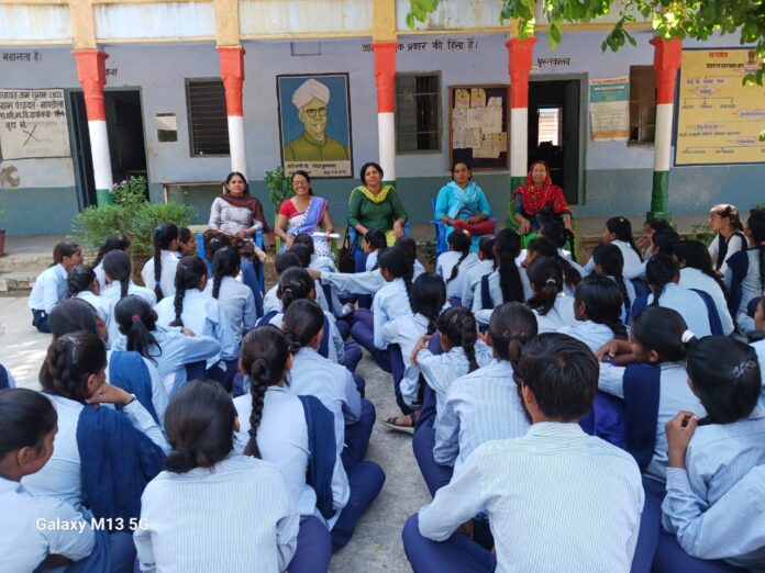 विद्यार्थियों को उचित खानपान के विषय में जागरूक करते स्कूल स्टाफ व स्वास्थ्य कर्मी।