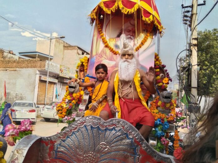 बाजार में शोभायात्रा निकालते हुए।