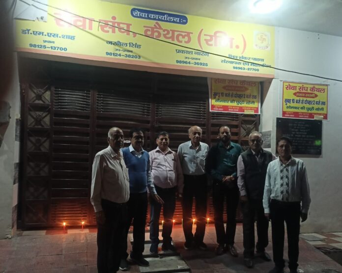 संस्था के पदाधिकारी दीए जलाते हुए