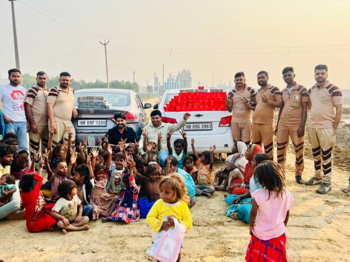 बच्चों को मिठाइयां व पटाखे बांटते हुए डेरे के सेवादार।