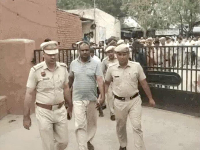 सचिव होशियार को कनीना कोर्ट में पेश करने ले जाती पुलिस।