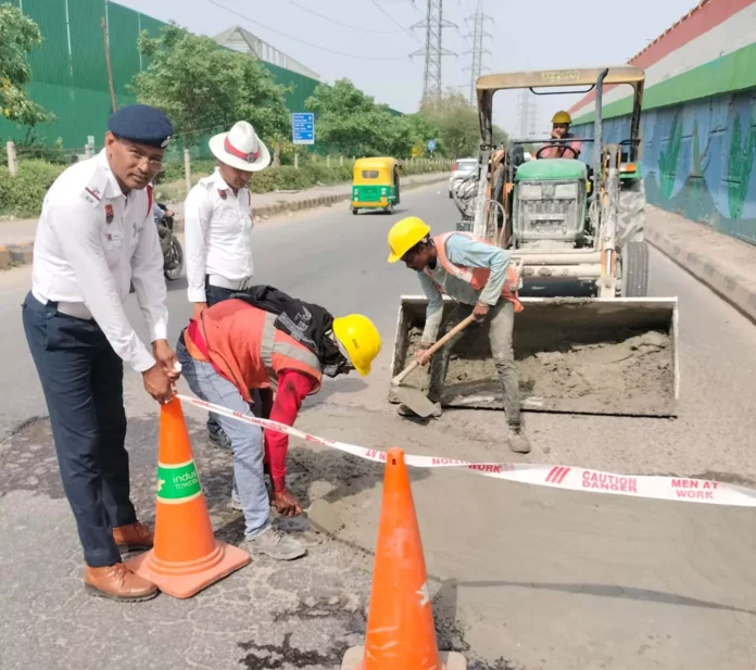 Gurugram News : पुलिस कर्मियों ने सुभाष चौक पर बने गड्ढों को भरवाया