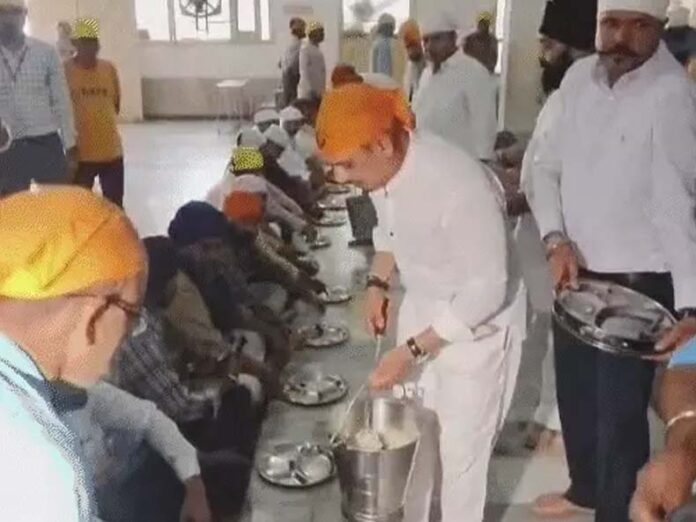 श्रद्धालुओं को प्रसाद का वितरण करते उद्योगपति राबर्ट वाड्रा।