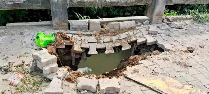 The pavement made of interlock tiles near the drain has collapsed, cars are getting stuck