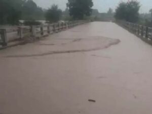 पुल के ऊपर से बहता पानी।
