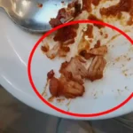 An uproar erupted after a piece of chicken was found in a vegetarian dish; the hotel management is accused of negligence.