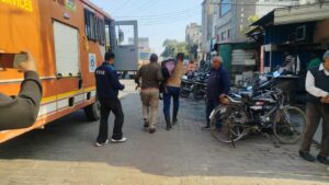 बच्ची को कंधे पर अस्पताल ले जाते हुए फायर ब्रिगेड कर्मचारी।